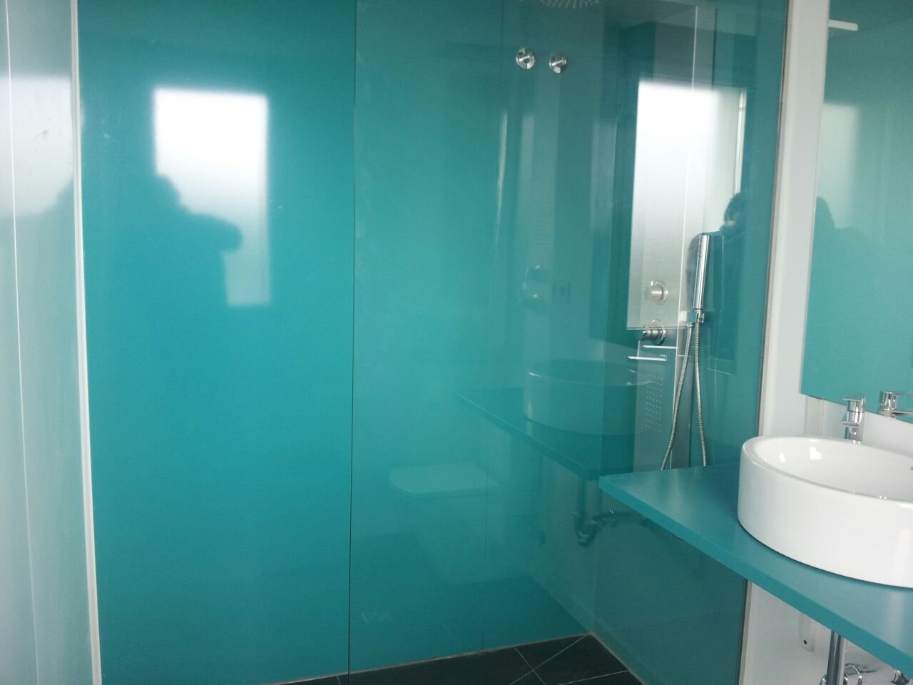 Baño reformado por Reformas CC García: acabado en cristal color turquesa