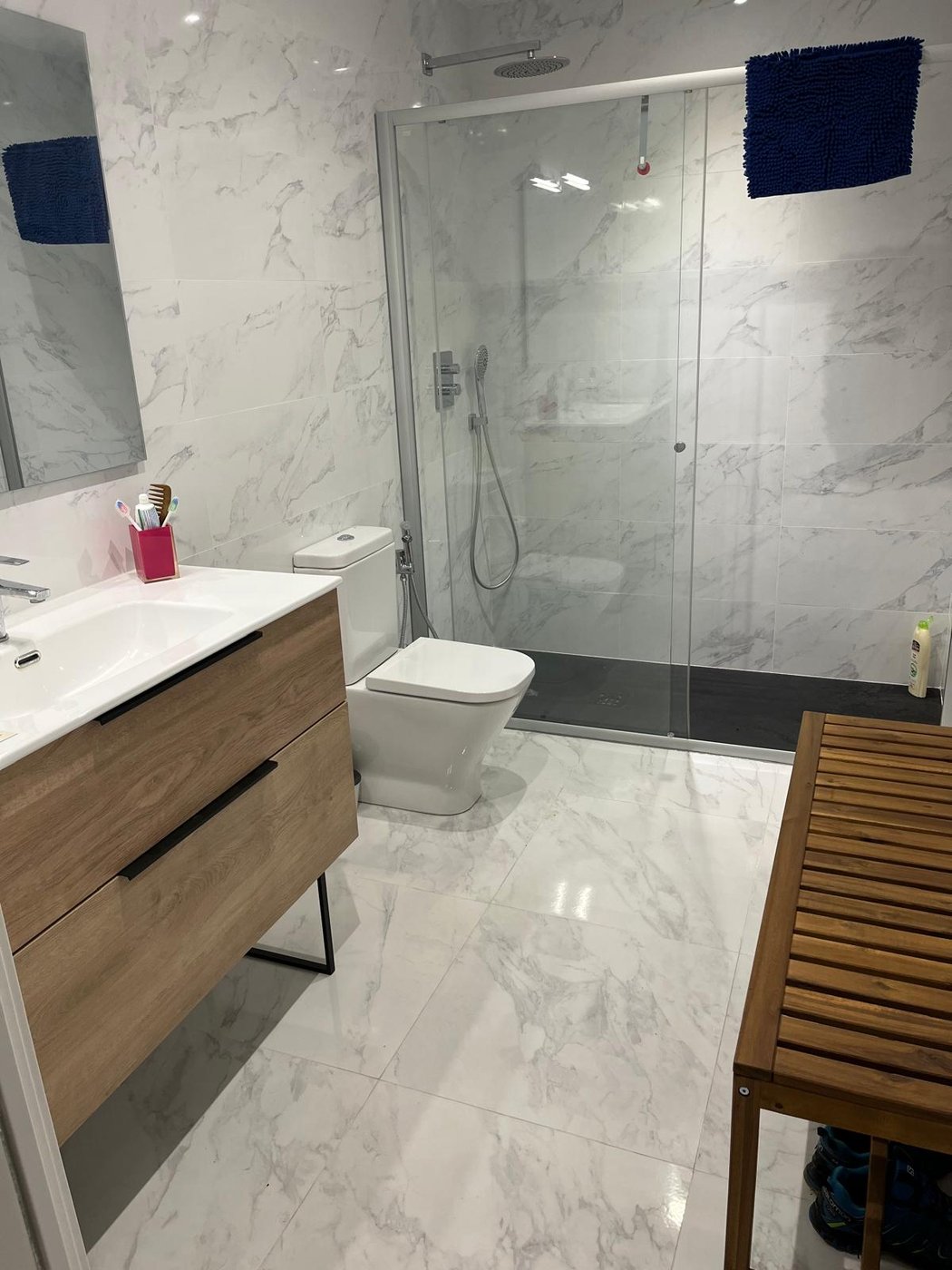 Baño reformado por Reformas CC García: acabado en mármol con ducha a ras de suelo